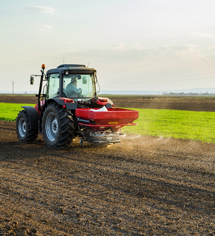 Farmer fertilizing arable land with nitrogen, phosphorus, potassium fertilizer